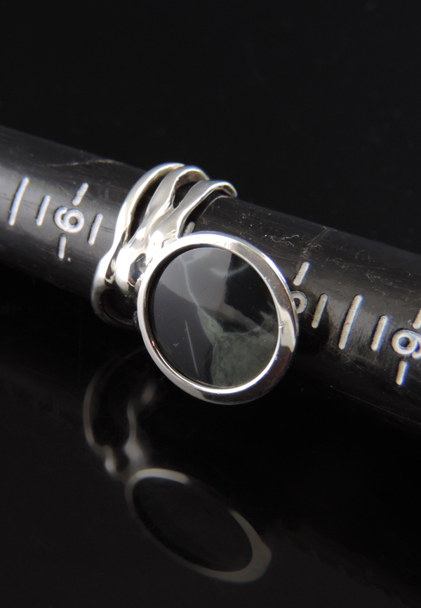 Dark and Stormy sterling silver ring featuring a smooth, round Spiderweb Obsidian gemstone with natural grey veining, set in a polished bezel with an artisan, fluidly sculpted, organic-style silver band.