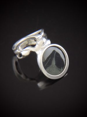 Dark and Stormy sterling silver ring featuring a smooth, round Spiderweb Obsidian gemstone with natural grey veining, set in a polished bezel with an artisan, fluidly sculpted, organic-style silver band.