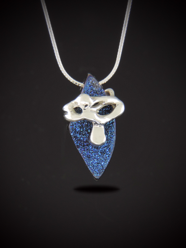 Front view of the Blue Flame necklace featuring a pointed, shield-shaped cobalt blue titanium druzy pendant wrapped in an abstract sterling silver custom casting on a silver snake chain against a dark gradient background.