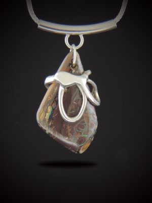 Alt Text: A vertical Australian Boulder Opal pendant with natural brown matrix and flashes of green and blue, encased in a custom-cast sterling silver wrap. The pendant hangs from a curved sterling silver tube bail on a woven foxtail chain.