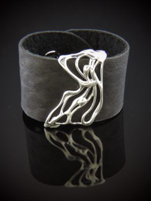 Bold black leather cuff bracelet with a wide matte band and sculptural sterling silver overlay in a fluid, freeform design. Modern minimalist statement piece, 1.5" wide, sized extra small/small.