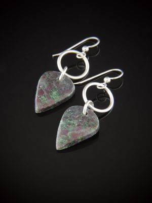 Pair of teardrop-shaped Ruby Fuchsite earrings with dark green and pink mottled patterns, hanging from sterling silver circular rings and earwires against a reflective black background.