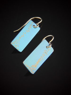 Crisp, contemporary titanium bar earrings featuring sleek rectangular drops in a soft aqua tone with subtle gold accents. Suspended from gold-filled fishhook ear wires, these minimalist geometric earrings offer a clean, modern silhouette with elegant movement. Approx. 1 3/8" long and 3/8" wide.