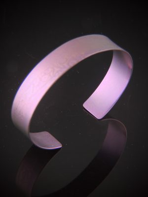 Pink titanium cuff bracelet with textured print and open design