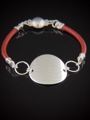 Sterling silver and red leather bracelet with textured 1-inch silver disk centerpiece and magnetic clasp