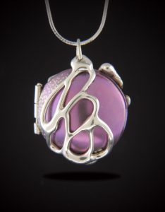 Titanium locket anodized in pink with organic sterling silver design.