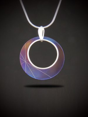 LAPD Nightshift circular pendant featuring torch-fired blue and violet titanium with hand-etched geometric lines and a sterling silver inner ring on a snake chain.