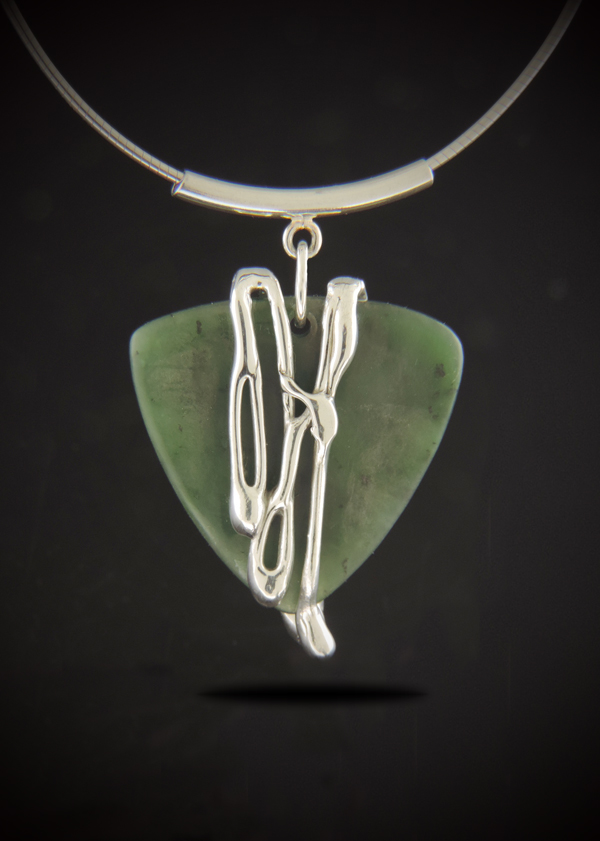 One-of-a-kind Jade Cocktail Necklace featuring a triangular guitar-pick shaped green Canadian nephrite jade with fluid sterling silver cascading down the front, hanging from a curved sterling tube bail and omega chain.